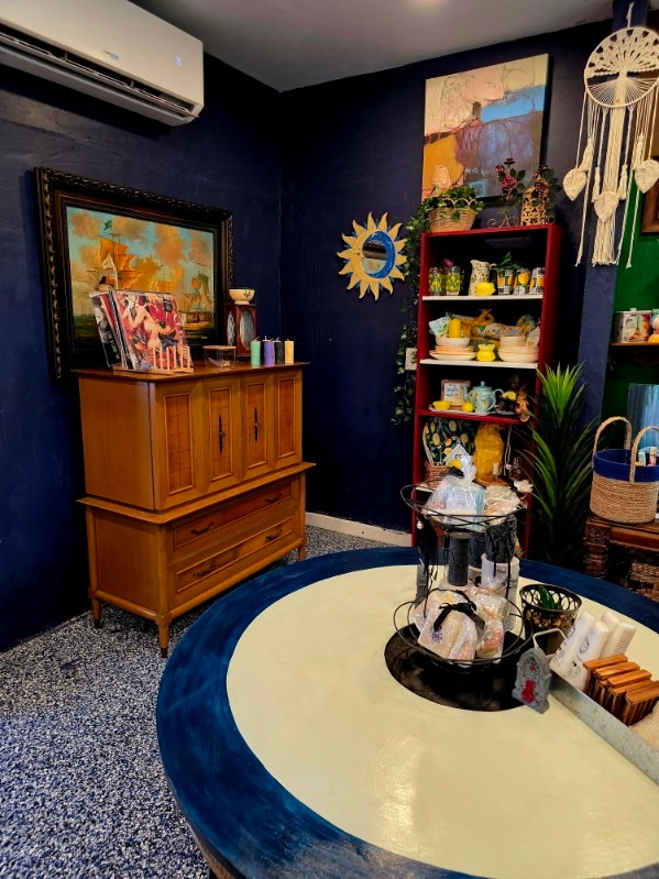 A navy-blue room featuring a ship painting and coastal display pieces